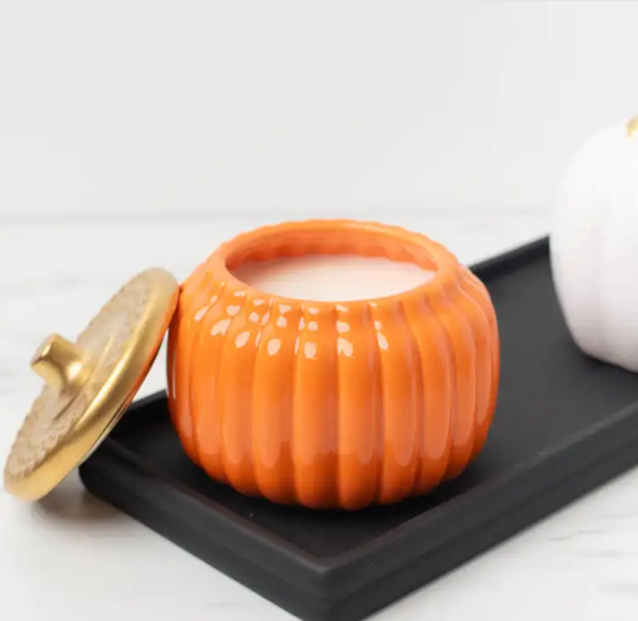 Beautiful ceramic pumpkin jar in orange color with golden lid