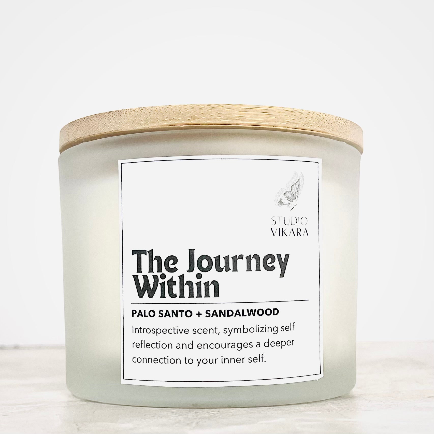 Studio Vikara's The Journey Within 10oz scented candle with wooden lid  and scents of relaxing palo santo and sandalwood. 