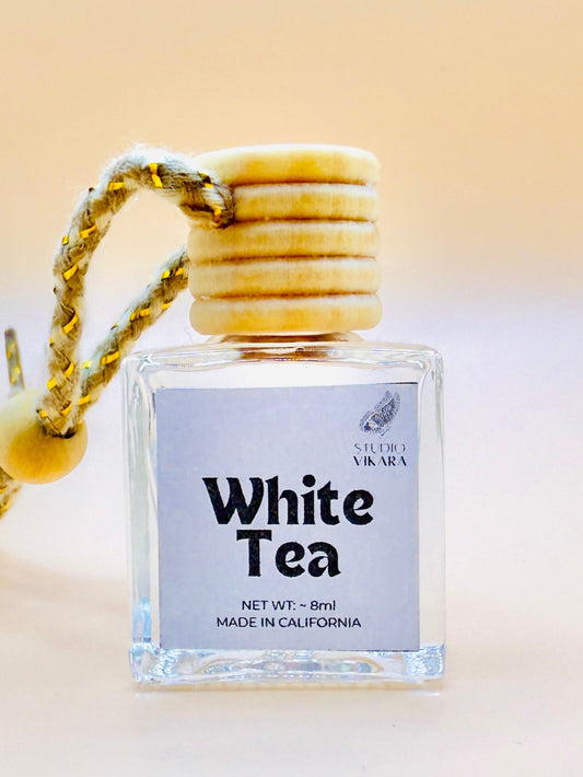 White Tea perfume bottle with wooden cap on a beige background