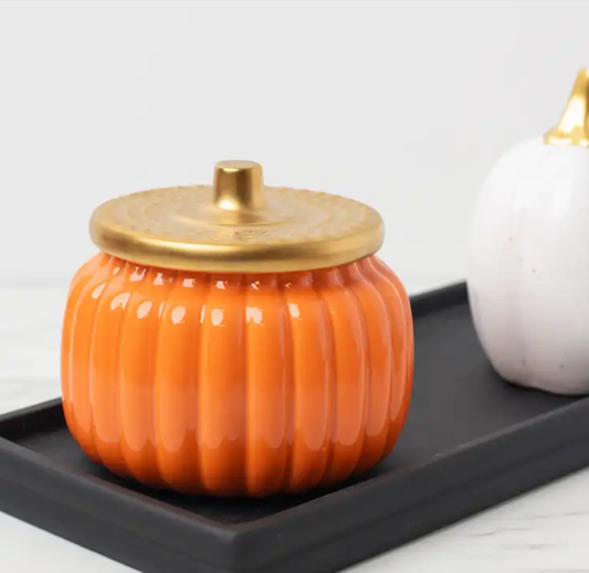 Beautiful ceramic pumpkin jar in orange color with golden lid